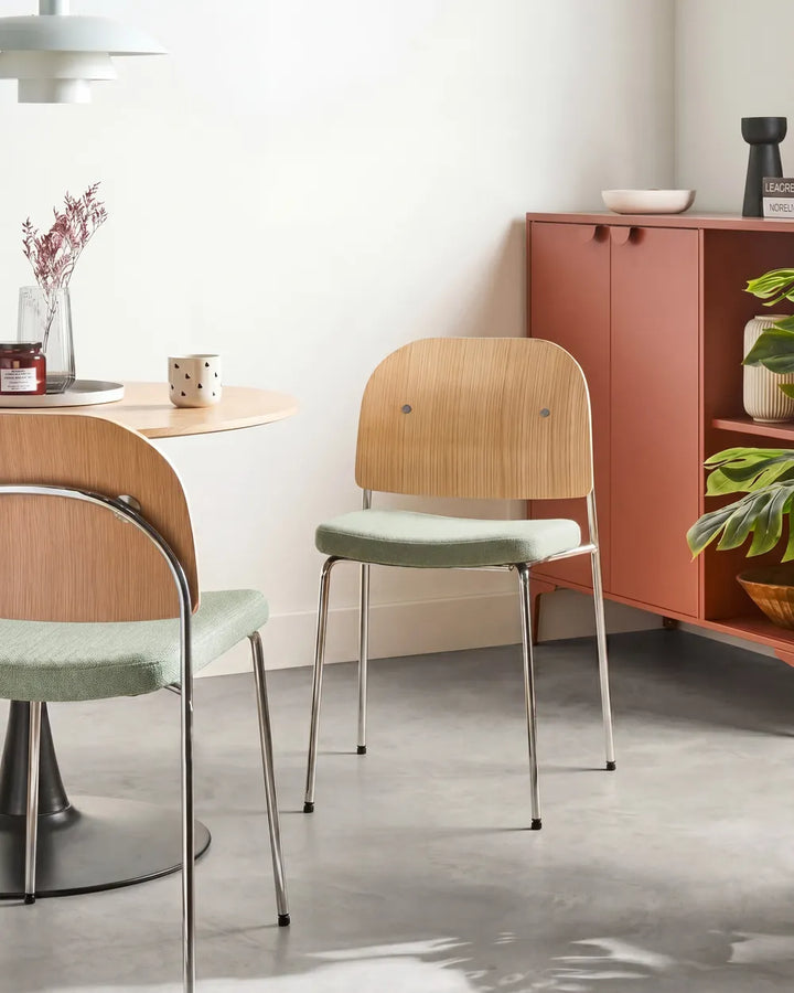 Dining area with wooden chairs and a cabinet in a room.