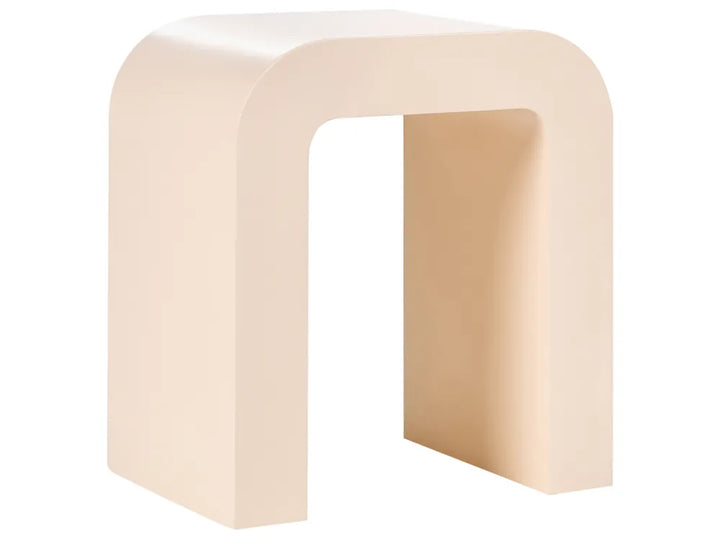 A minimalist U-shaped side table or stool in a warm cream-beige finish, shown from a three-quarters perspective against a solid white background.