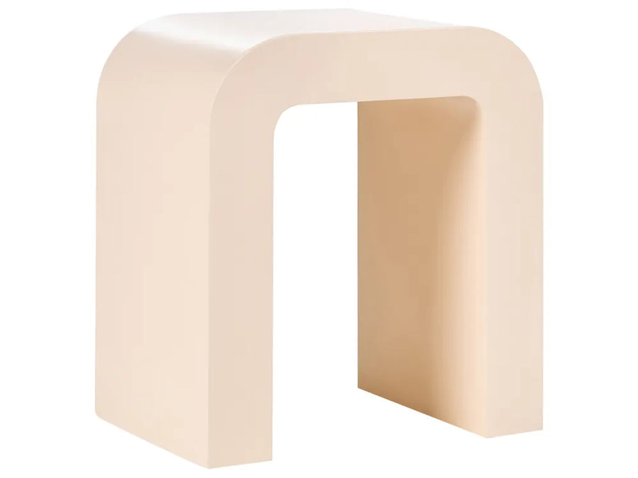 A minimalist U-shaped side table or stool in a warm cream-beige finish, shown from a three-quarters perspective against a solid white background.