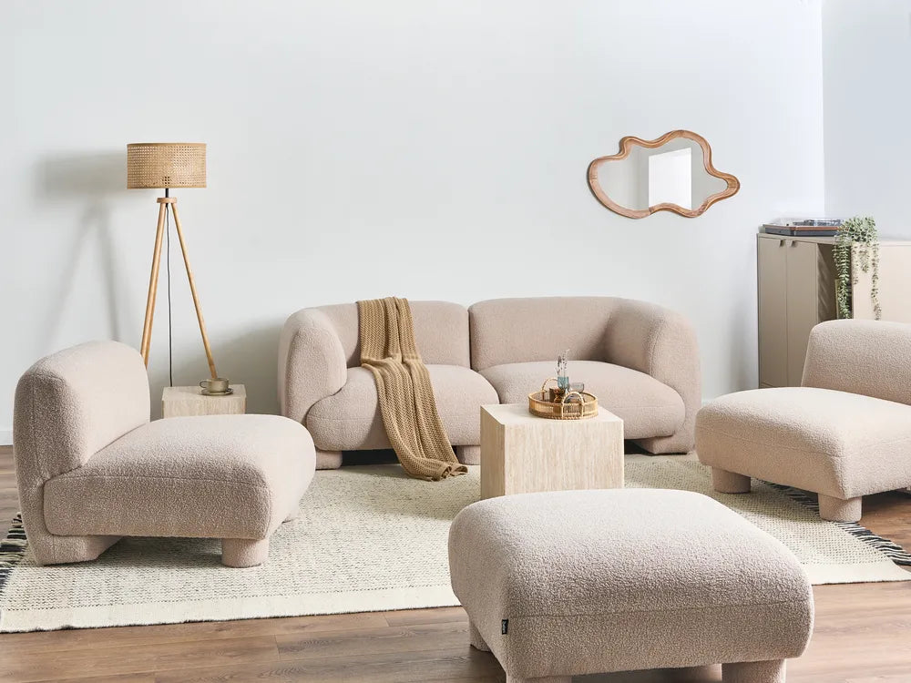 Beige living room furniture set with a lamp and mirror on a white wall.