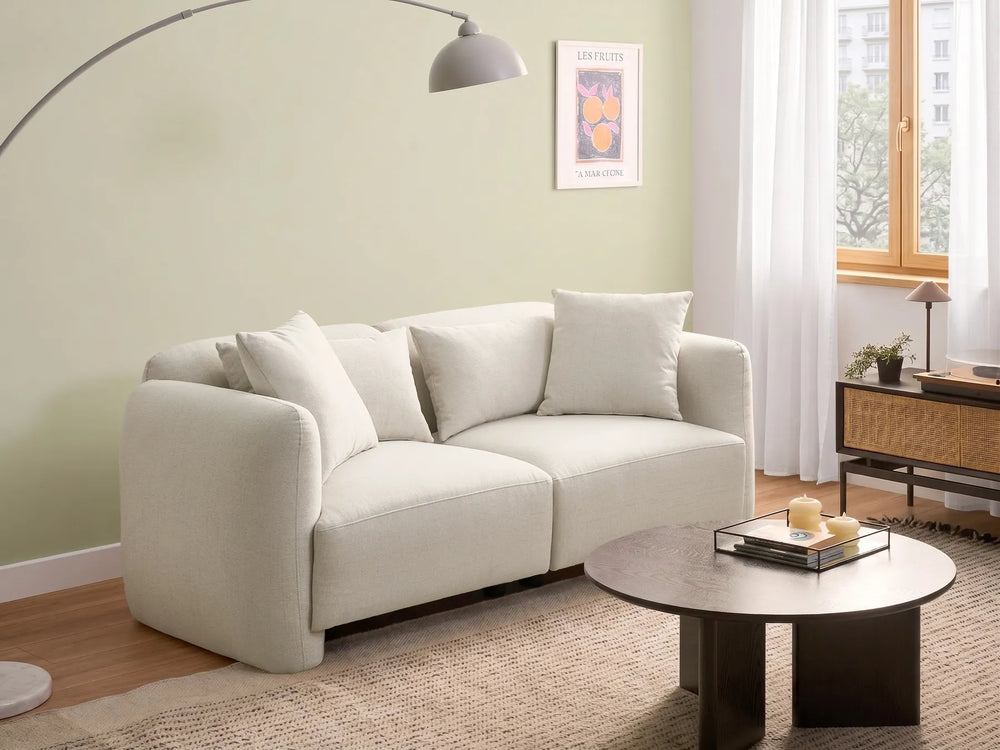 White sofa in a living room with a coffee table and decor items.