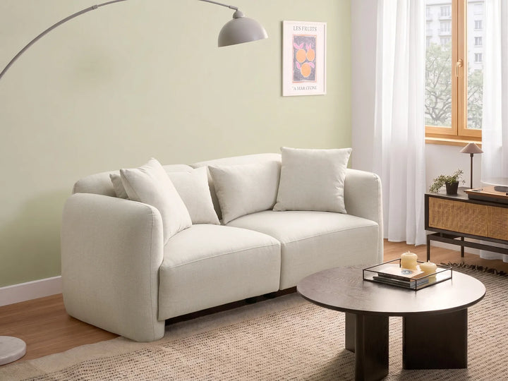 White sofa in a living room with a coffee table and decor items.