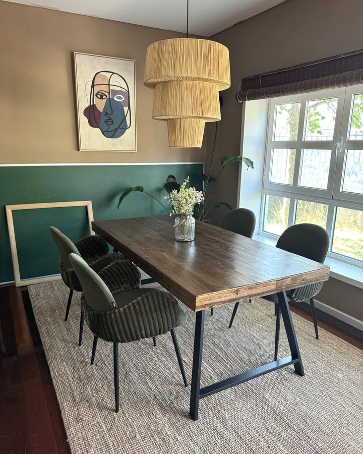 Dining room with wooden table and chairs, framed art on the wall, and a large window.