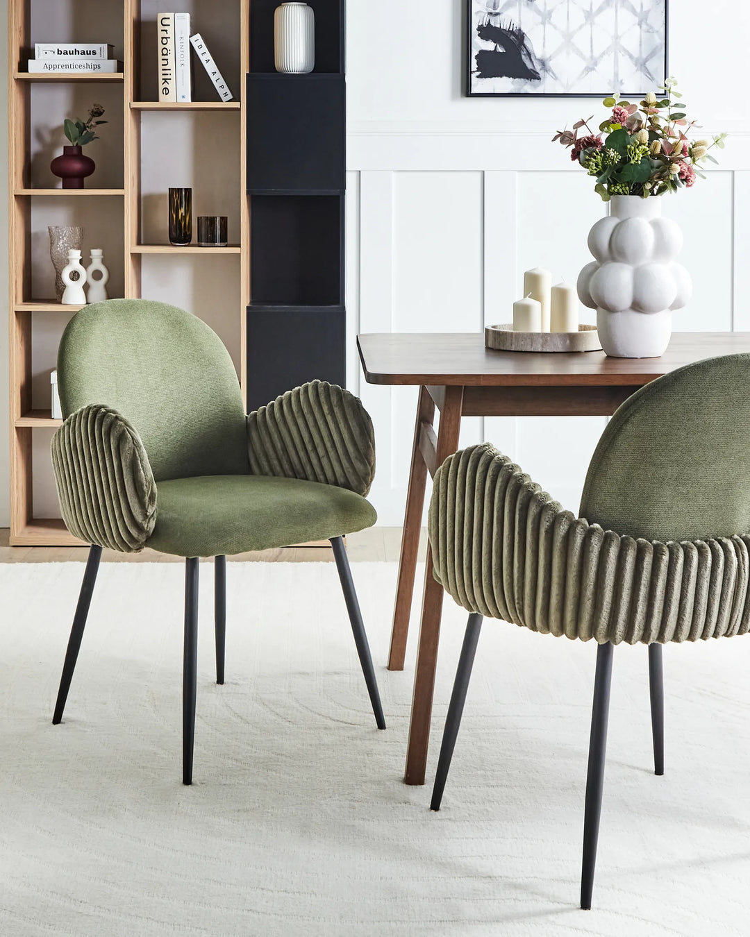 Two green chairs in a modern living room setting with a wooden table and decor.