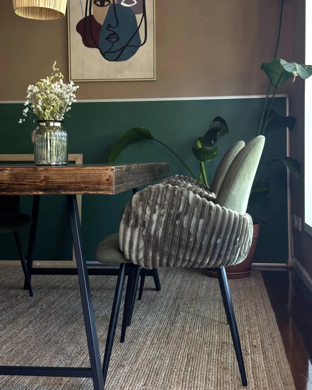 Gray cushioned chair in a room with a wooden table and decorative elements.