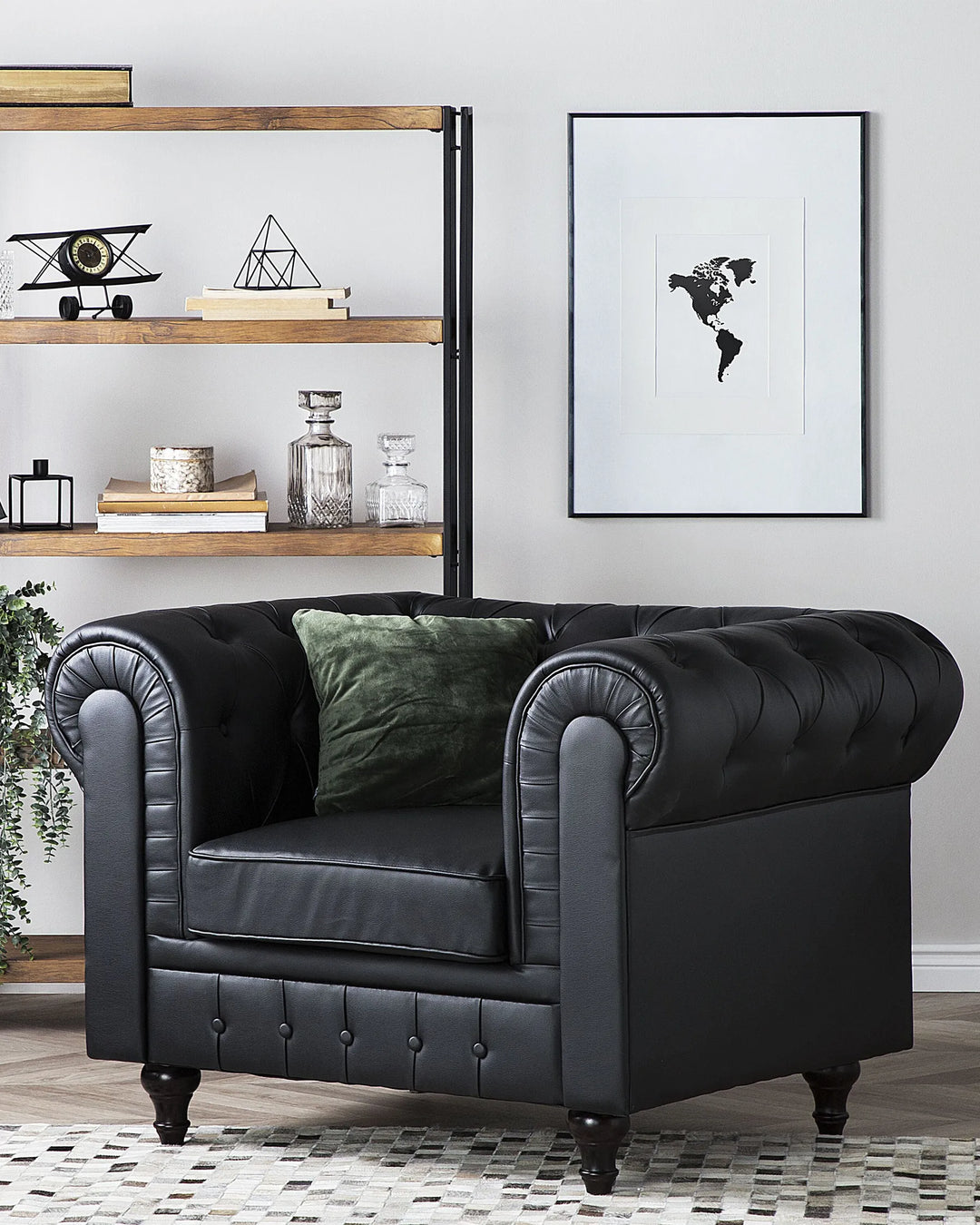 Black leather armchair in a living room setting with a world map poster on the wall.