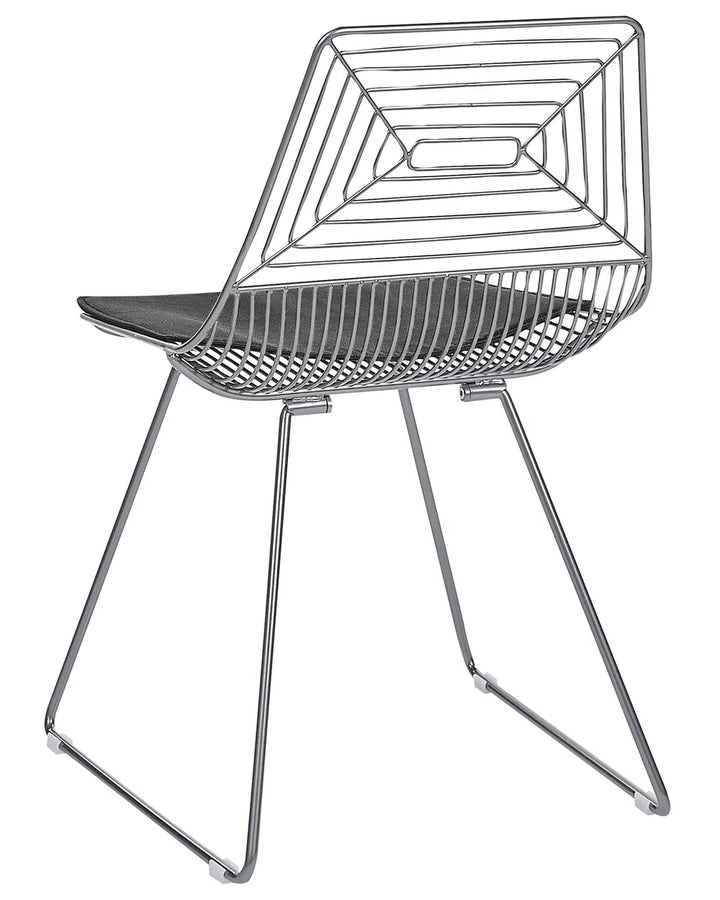 A modern wireframe dining chair with a geometric backrest and seat, featuring a dark gray cushion on a polished silver metal frame.