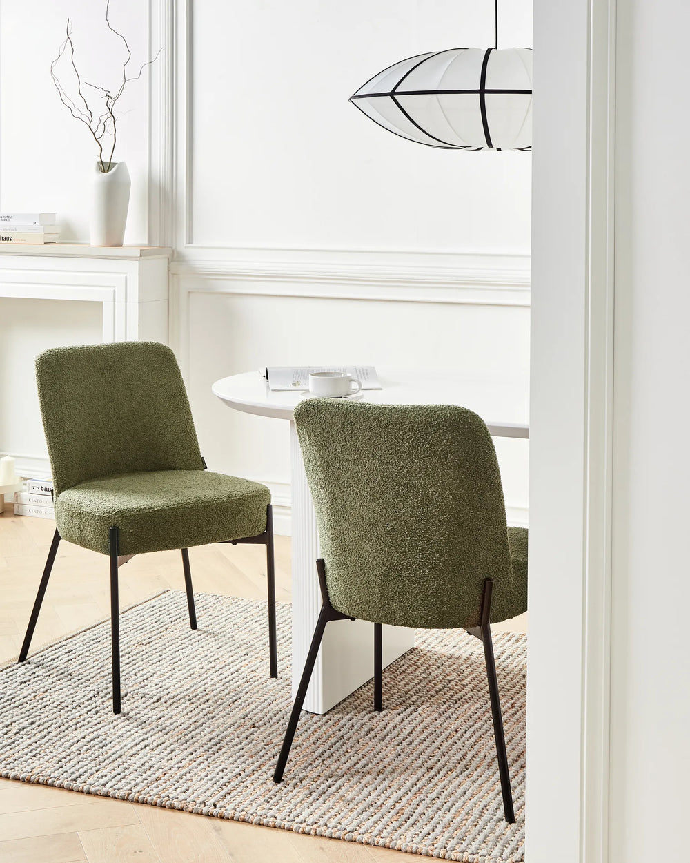 Two green chairs in a modern dining room setting.