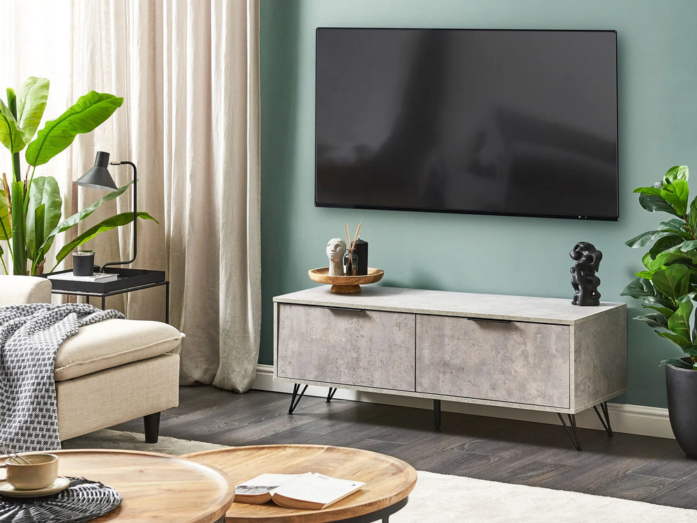 Modern living room with a TV mounted on the wall, a gray entertainment console, and decorative items.