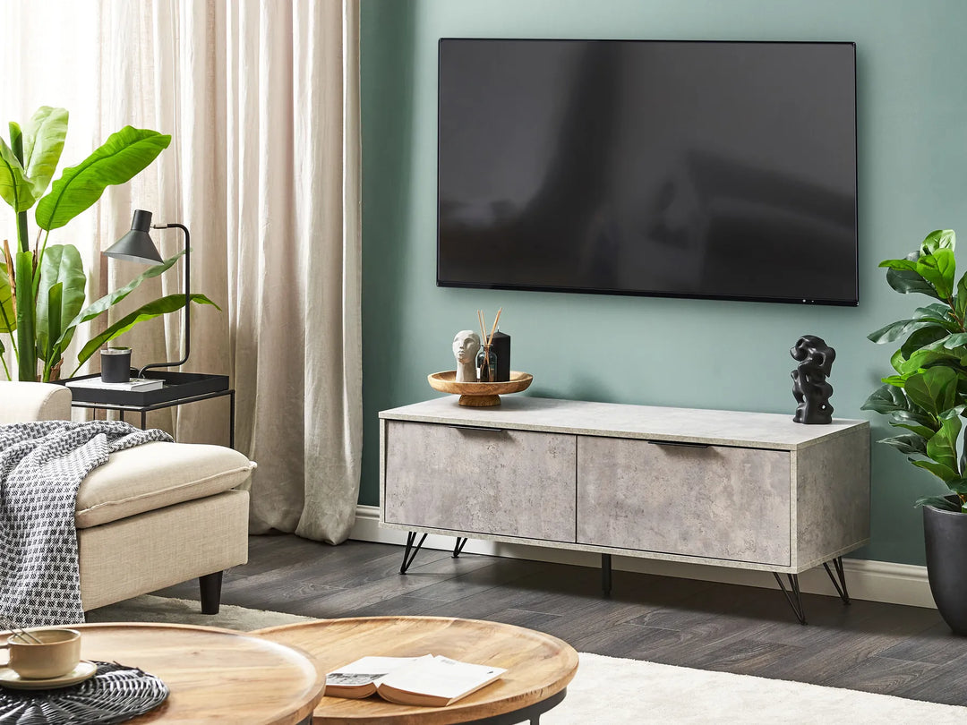 Modern living room with a TV mounted on the wall, a gray entertainment console, and decorative items.
