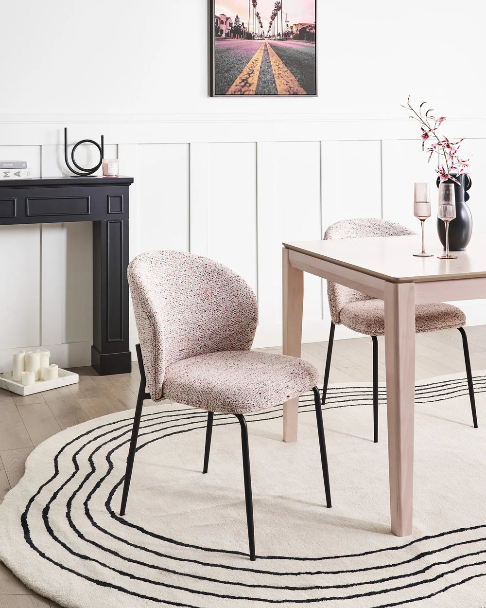 Dining room with a table and chairs on a black and white striped rug.