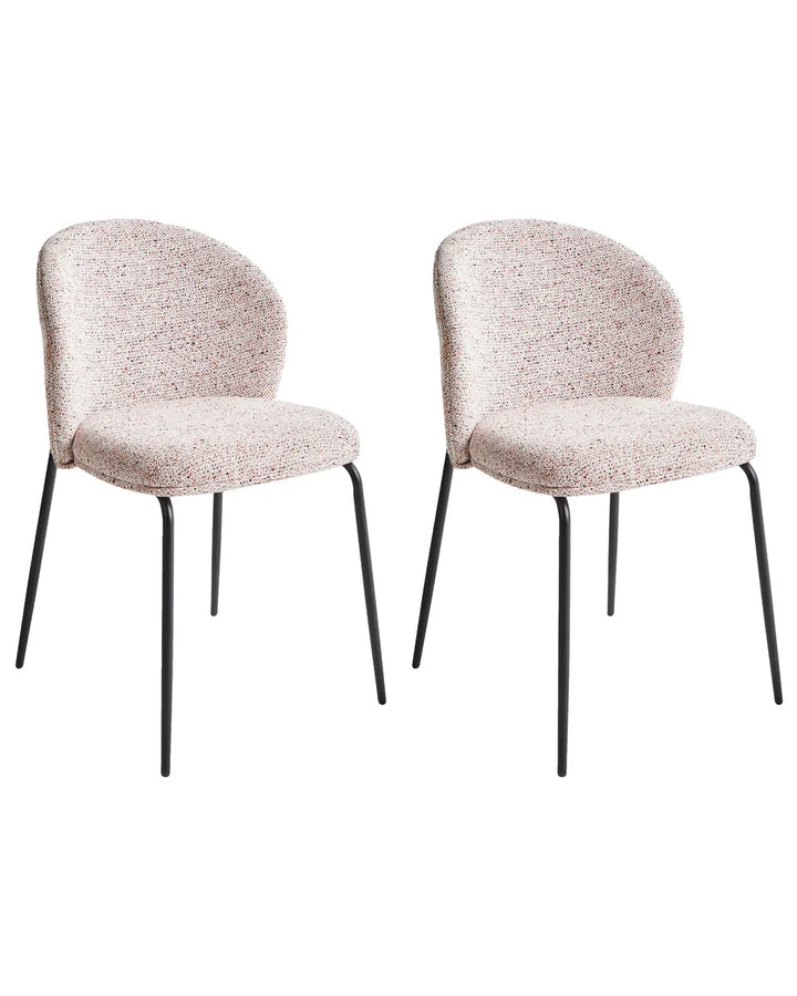 Two matching upholstered dining chairs with curved backs and seats, upholstered in a light beige fabric with a subtle pink and white speckled pattern, supported by slim black metal legs.