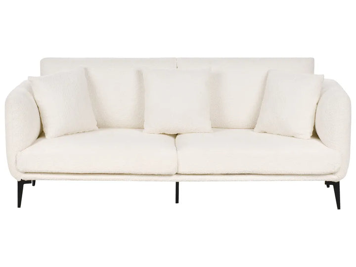 A modern three-seat sofa upholstered in a textured off-white fabric, featuring four matching square throw pillows and slim black metal legs, shown against a plain white background.