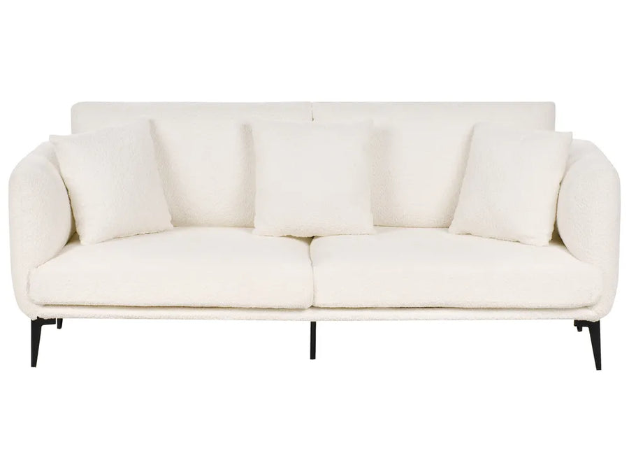 A modern three-seat sofa upholstered in a textured off-white fabric, featuring four matching square throw pillows and slim black metal legs, shown against a plain white background.