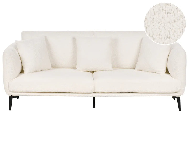 An off-white bouclé three-seater sofa with matching throw pillows and slim black legs, shown against a plain white background with a circular fabric texture inset in the top right corner.