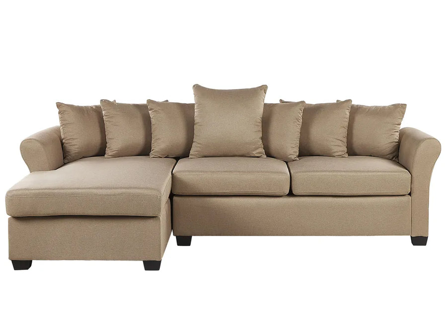 A beige fabric sectional sofa with a left-facing chaise lounge, featuring multiple matching throw pillows and dark legs, shown against a plain white background.