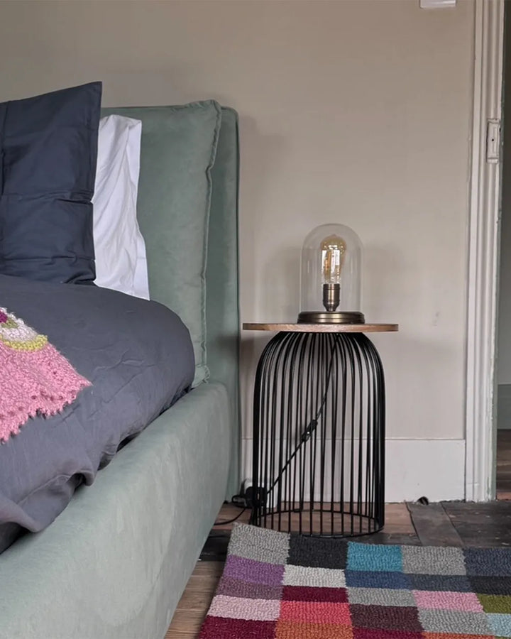 Bedroom with a bed, nightstand, and colorful rug.