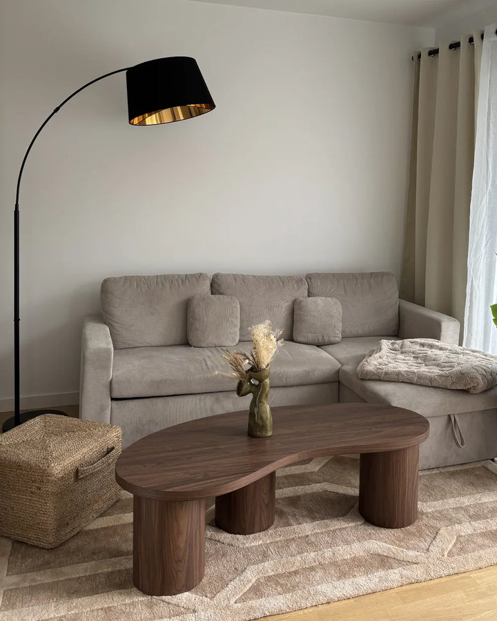 Modern living room with a gray sectional sofa, wooden coffee table, and floor lamp.