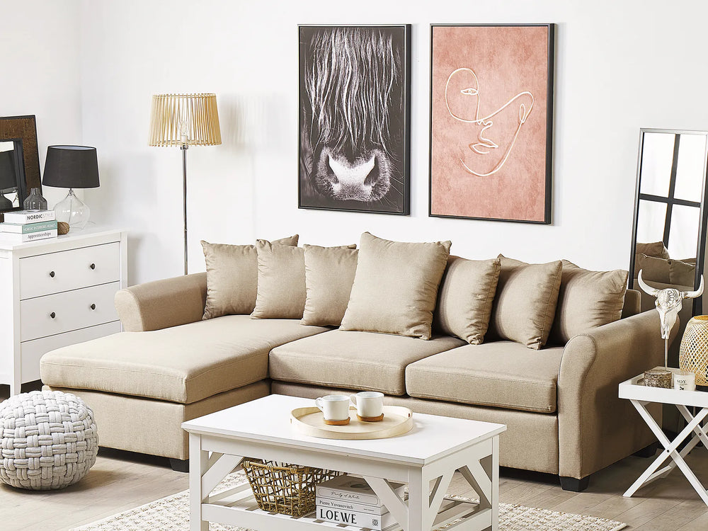 Beige sectional sofa in a living room with decorative items and artwork on the wall.
