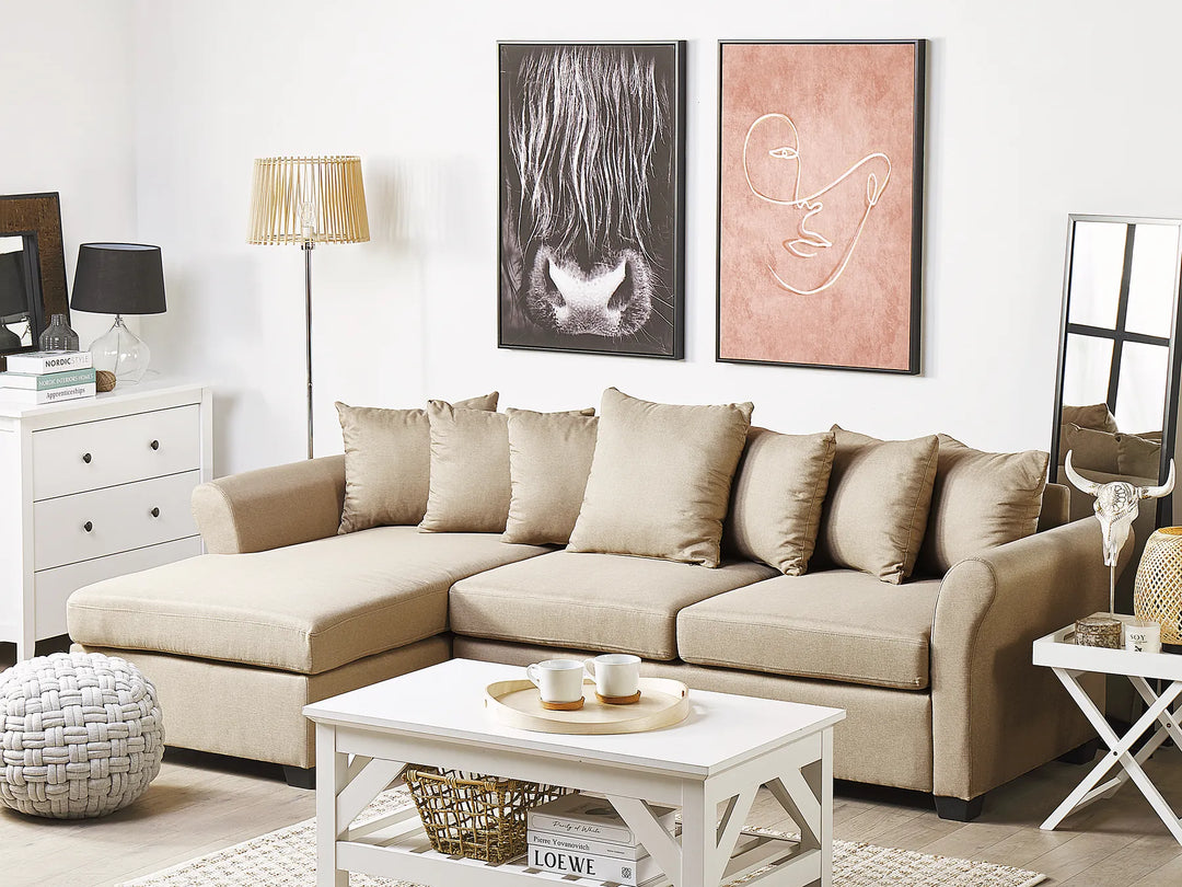 Beige sectional sofa in a living room with decorative items and artwork on the wall.