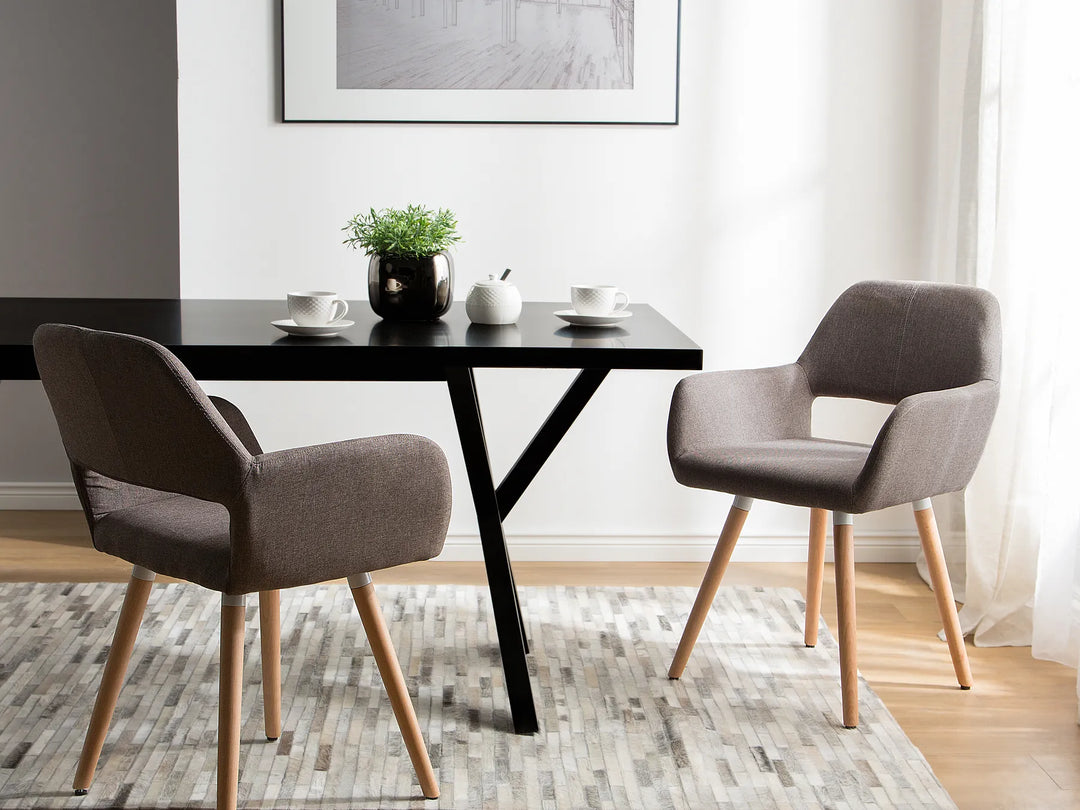 Modern dining area with black table and gray chairs in a well-lit room.