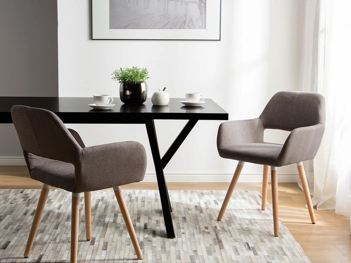 Modern dining area with black table and gray chairs in a well-lit room.