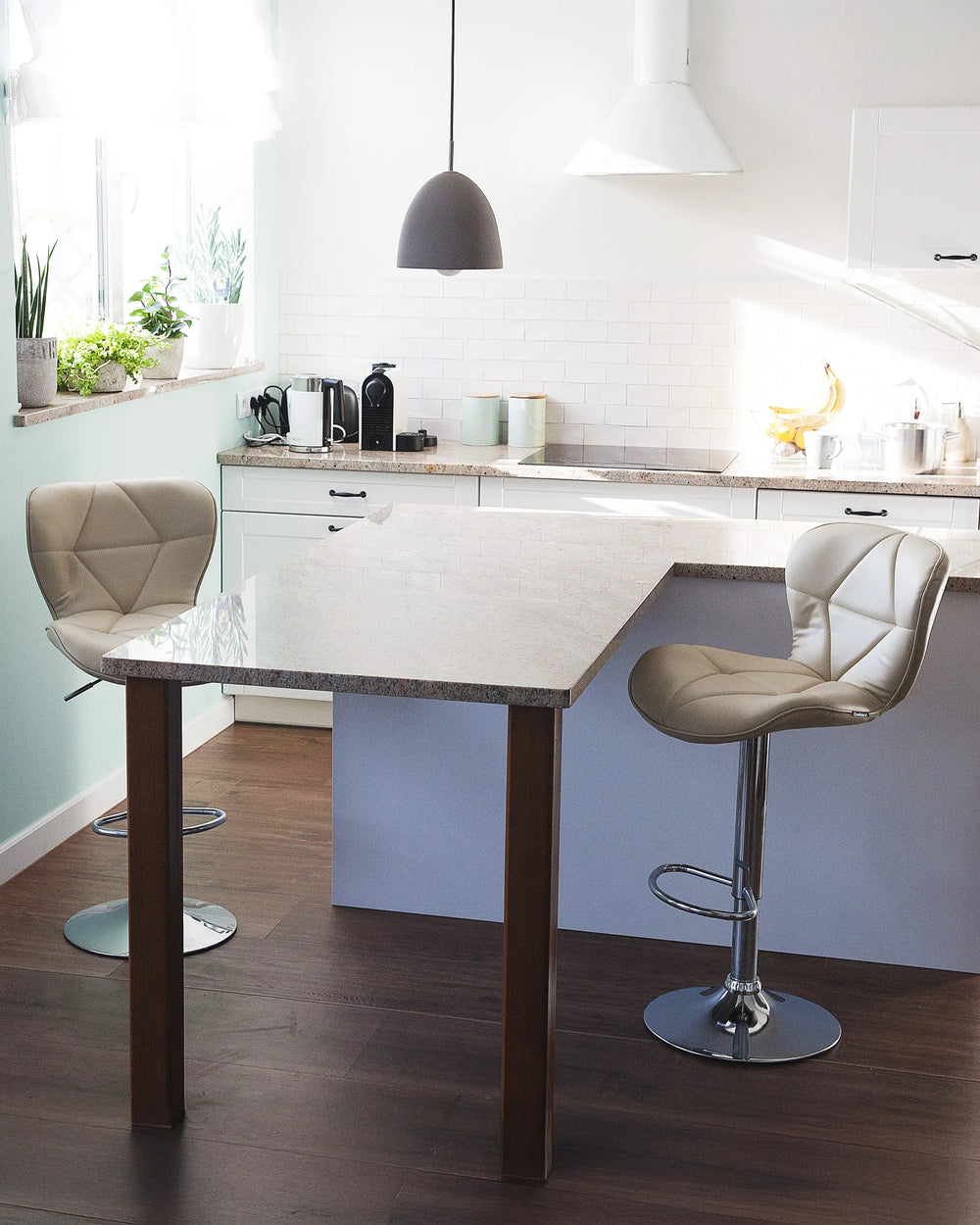 Modern kitchen with a white island and bar stools.