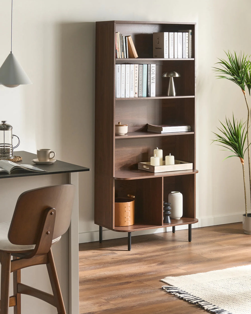 Wooden bookshelf with decorative items in a modern room setting.