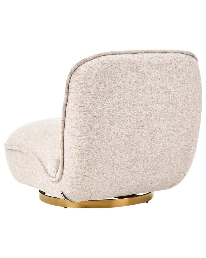 A modern upholstered accent chair with a rounded, low-profile silhouette, featuring a textured light beige fabric and a polished gold circular metal base, shown against a solid white background.