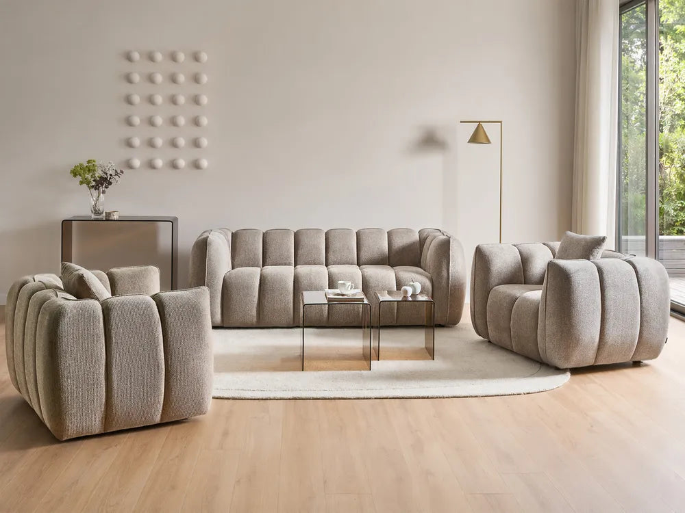 Beige sofa set in a modern living room with large windows.