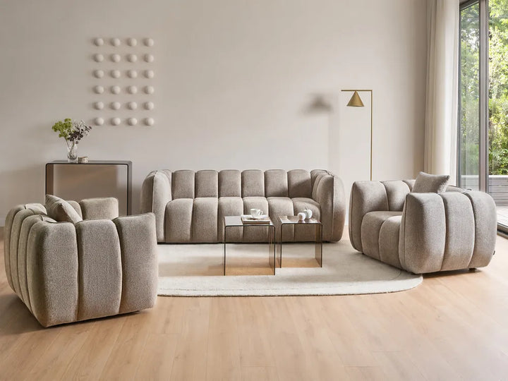 Beige sofa set in a modern living room with large windows.