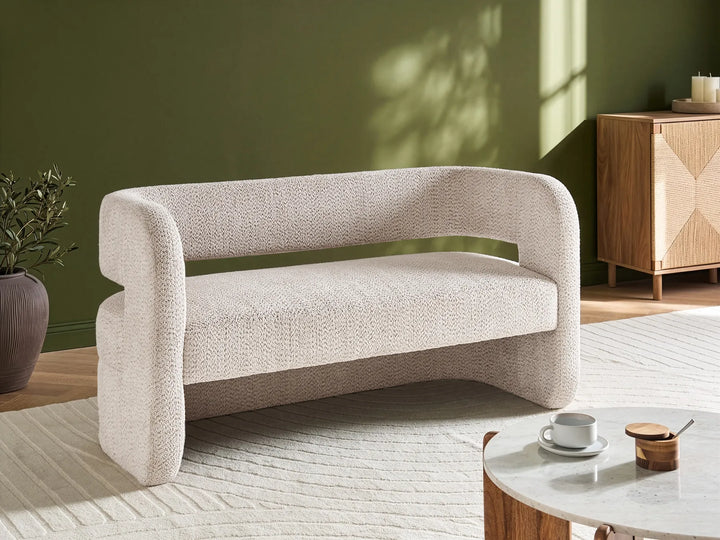 Beige sofa in a room with a green wall and wooden cabinet.