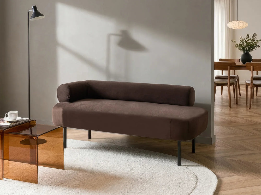 Brown sofa in a modern living room with wooden coffee table and dining area.