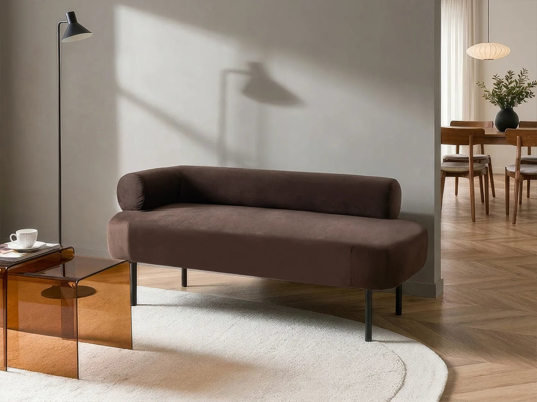 Brown sofa in a modern living room with wooden coffee table and dining area.