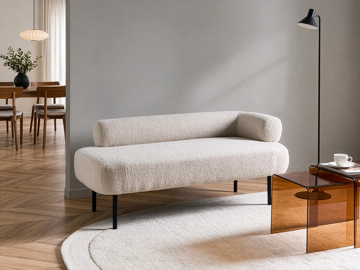 Modern beige sofa in a living room setting with a lamp and coffee table.