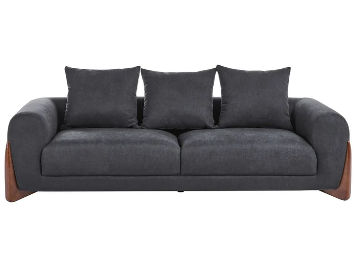 A modern three-seater sofa upholstered in dark charcoal gray fabric, featuring three matching back cushions and angled wooden legs, shown against a plain white background.