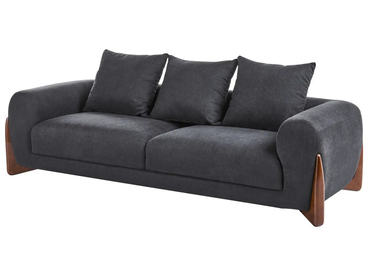 A modern three-seater sofa upholstered in dark charcoal gray fabric, featuring three matching back cushions and contrasting medium-brown wooden legs, shown against a plain white background.