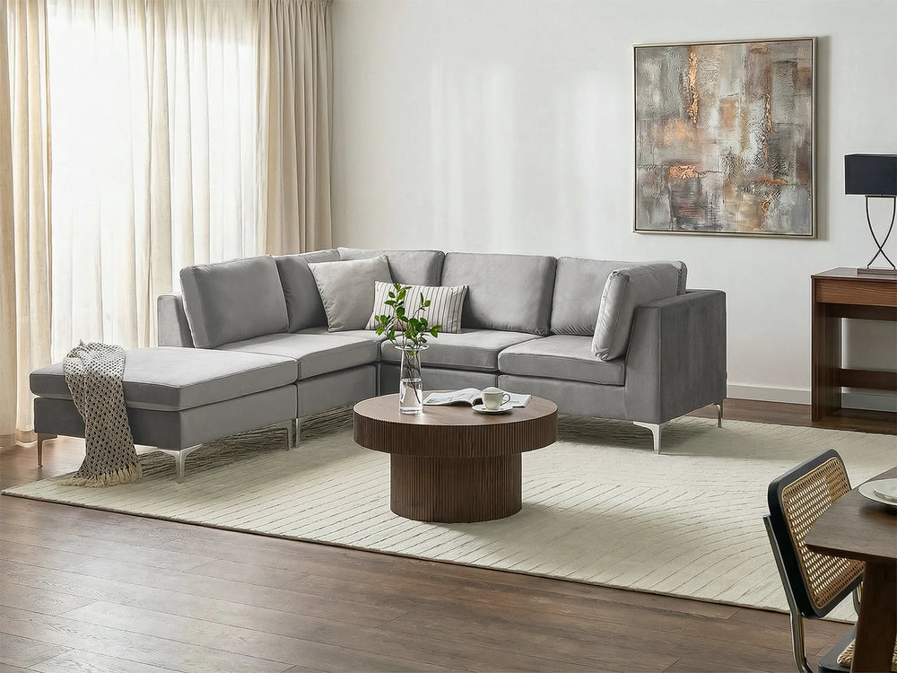 A modern light gray fabric sectional sofa with a chaise lounge on the right side.