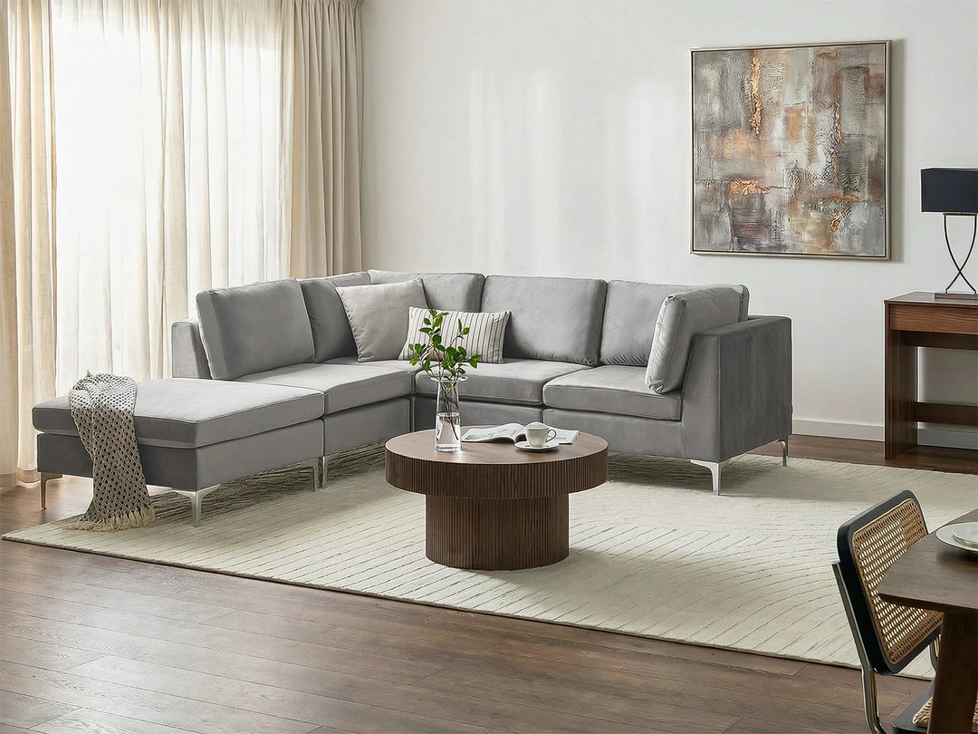 A modern light gray fabric sectional sofa with a chaise lounge on the right side.