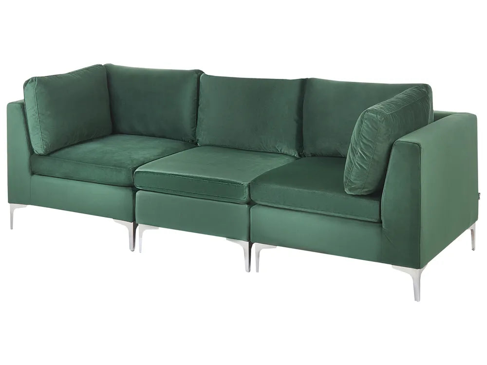 A modern three-seat sofa upholstered in deep green velvet, featuring slim silver metal legs, shown against a plain white background.