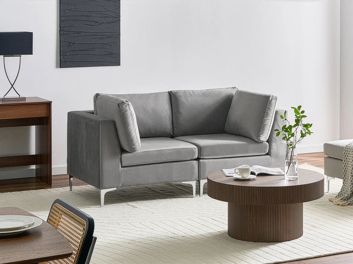 Modern living room with a gray sectional sofa, wooden coffee table, and decorative elements.