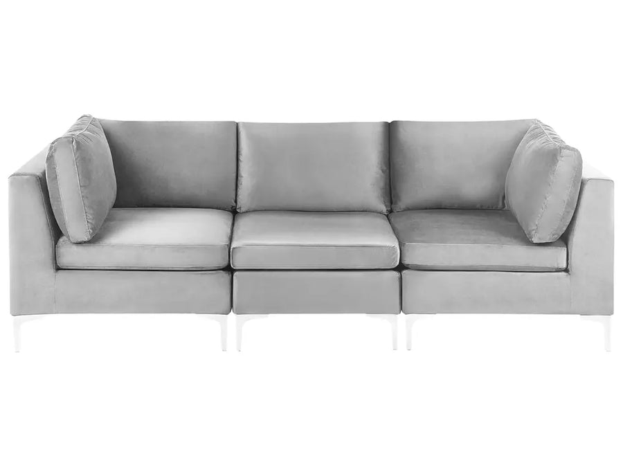 A modern three-seater sofa upholstered in light gray fabric, featuring a low-profile rectangular design with matching back and arm pillows, shown against a plain white background.