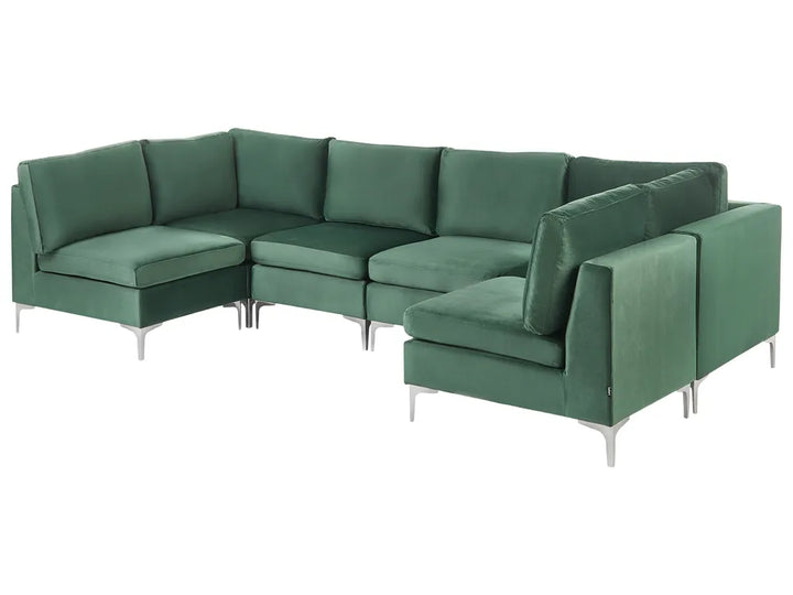 A modern sectional sofa in a rich green velvet fabric with slim silver metal legs, shown against a plain white background.