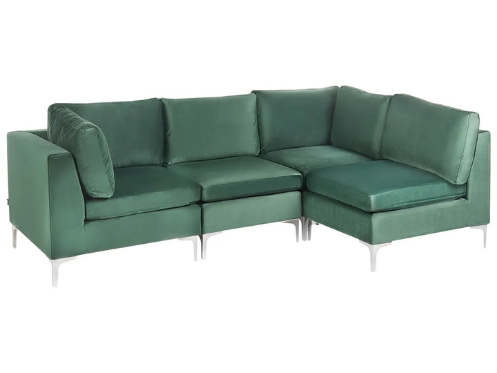 A modern L-shaped sectional sofa upholstered in deep green velvet, featuring slim silver metal legs, shown against a plain white background.