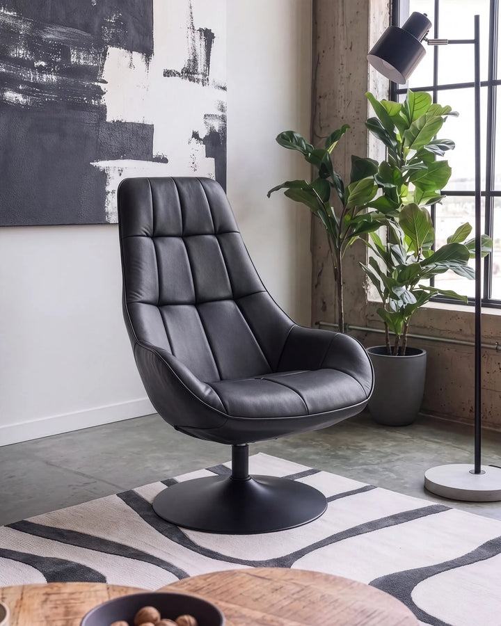A black leather swivel lounge chair with a tufted backrest, shown in a modern living room setting with a patterned rug, potted plant, and abstract wall art.