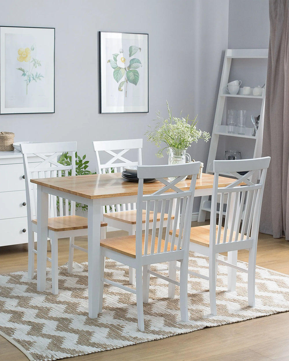 Dining room with wooden table and white chairs on a patterned rug.