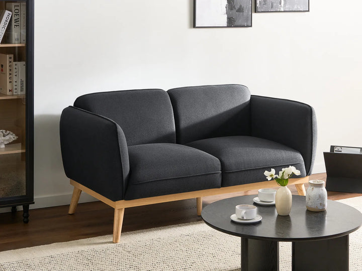 Gray sofa in a living room with a coffee table and decorative items.