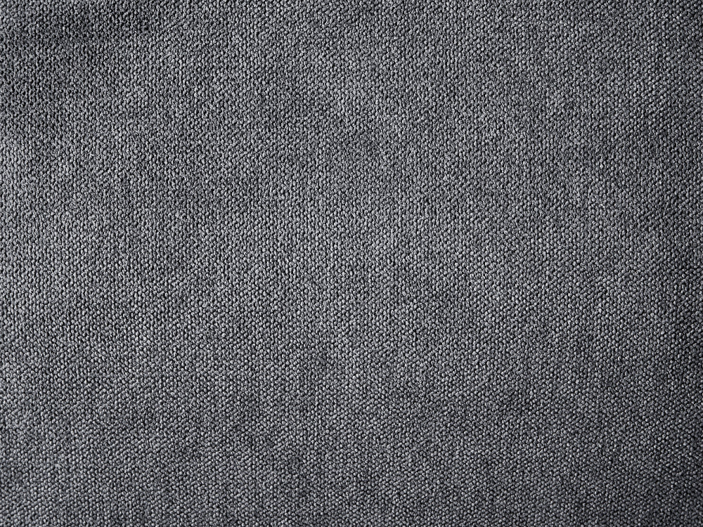 A close-up texture shot of a dark gray woven fabric, showing a fine knit or tweed pattern.