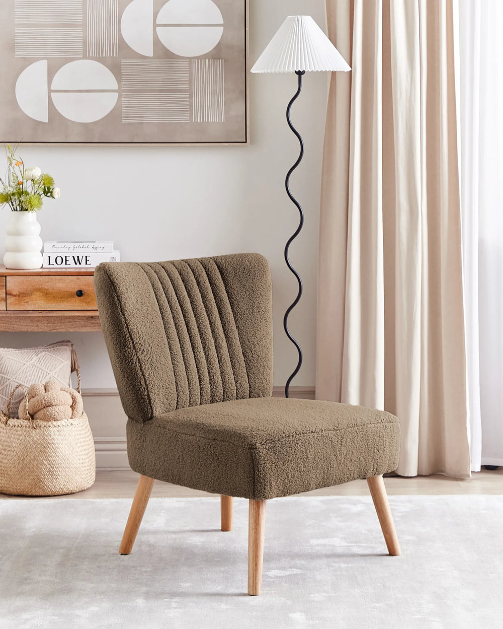 Brown upholstered chair in a room with a lamp, decor, and a desk.