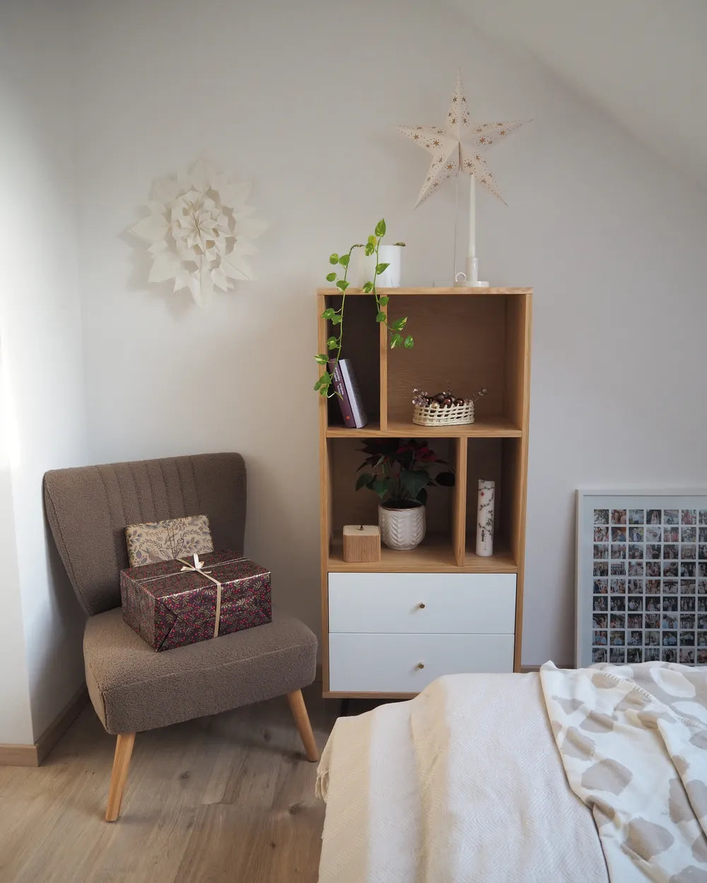 Nest living room with a brown armchair, wooden shelf, and bed.